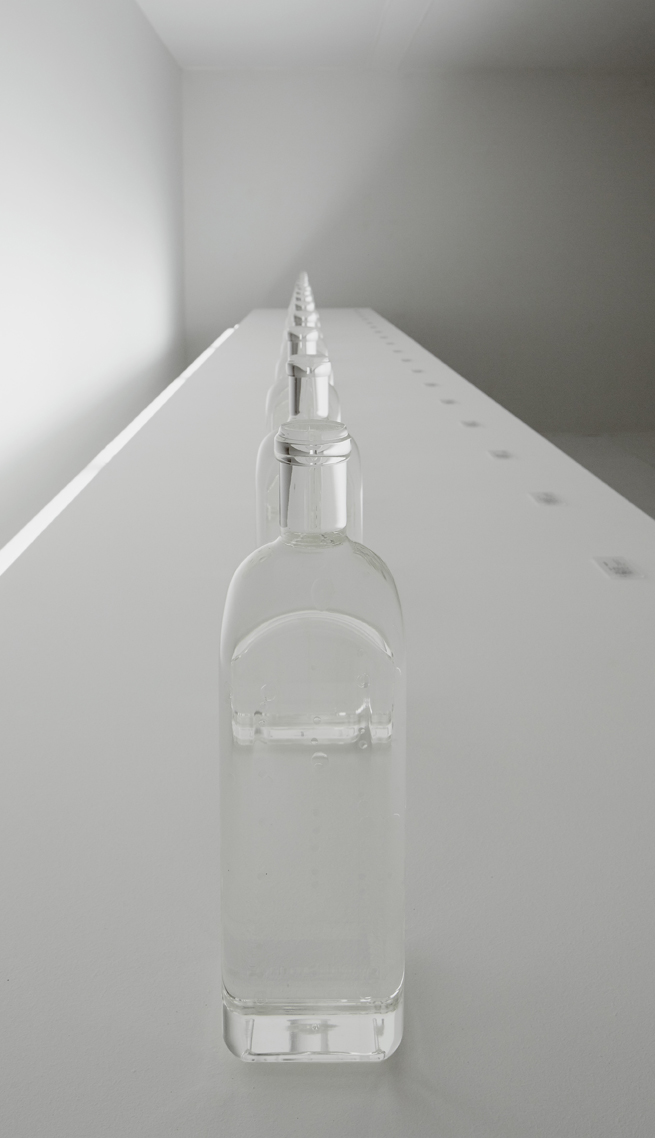 nendo creates glass bottle capturing the ripples of natural spring